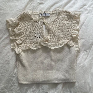 Vit spetsdetaljerad topp från Zara - Säljer en så fin oxh söt beiget topp från Zara med spetsdetaljer och volanger. Den är oanvänd och har lappen kvar då jag inte fått användning för den🩷
