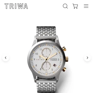 Ivory Lansen Chrono från Triwa - Stilren klocka från Triwa med en silverfärgad mesharmband och vit urtavla. Klockan har guldiga detaljer och en kronograf-funktion. Jag har kortat ner länken men går att fixa tillbaka till den normala storleken! Perfekt för den som söker en elegant och tidlös accessoar.Hör av er vid frågor 
