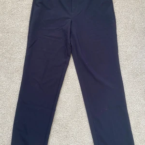 Svarta byxor från LMTD - Snygga svarta byxor från LMTD i en klassisk stil. Byxorna har en rak passform och är perfekta för en stilren look. De är tillverkade i ett bekvämt material och har hällor för bälte.