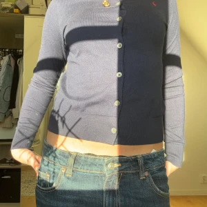 Mörkblå kofta från Ralph Lauren - Säljer en stilren mörkblå kofta från Ralph Lauren med knappar framtill och ett litet rött logotypbroderi på bröstet i storlek XS, använd två gånger🩷 nypris 2599, pris går att diskutera🤗🤗💓💓