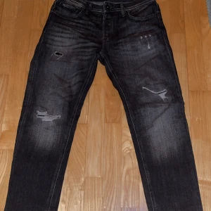 JJ Mike tapered fit 28/32 - Jack and Jones jeans i storlek 28/32 snygga slitningar och en slim fit passform. Väldigt snygga nu till sommaren. Pris kan diskuteras