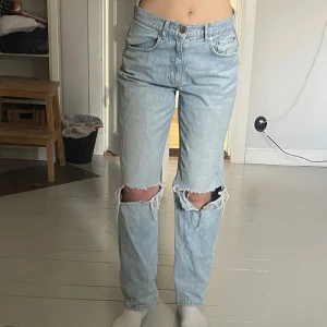 Ljusblå jeans med slitningar från Gina - Säljer ett par ljusblå jeans från Gina med slitningar vid knäna i storlek 38🥰. 