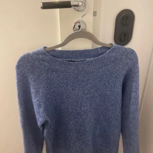 Blå stickad tröja från Vero Moda - Säljer en mysig blå stickad tröja från Vero Moda. Perfekt för kyliga dagar med sin mjuka och bekväma passform. Tröjan har långa ärmar och en rund halsringning.