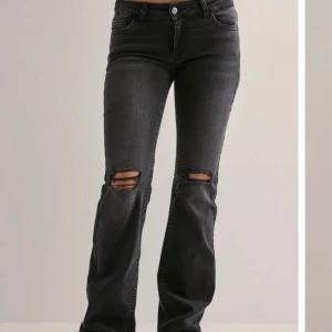 Svarta bootcut jeans med slitningar - Säljer ett par svarta bootcut jeans med slitningar över knäna från Nelly. Använda 1 gång så de är som nya men säljer då de va för stora på mig💘🙌🏻