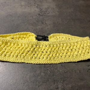 Virkat hårband gult - Här är ett virkat hårband i en ljusgul färg. Hårbandet har ett intrikat virkat mönster med resår. 48x5 cm Bomull