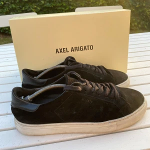Axel Arigato skor - Säljer ett par riktigt snygga axel arigato skor🔥 | säljer pga att de inte passar längre | självklart också äkta | det som följer med är skor, box och kort📦| skorna är i ett sparsamt skick det ända defekten är att skorna är lite smutsiga och har ett litet hål i hälen och att stitshingen på båda skorna är borta, men hålet varken syns eller känns vid använding, men stishingen på sidorna kan synas och märkas | kan gå ner i pris vid snabb affär | skriv gärna vid funderingar eller om fler bilder | 🙌🙌🙌