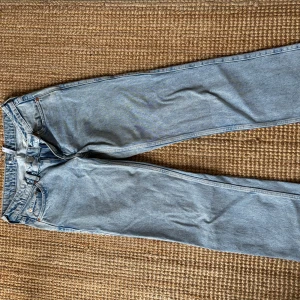Ljusblå jeans från Weekday Arrow - Säljer ett par ljusblå jeans från Weekday, modell Arrow. Jeansen har klassisk femficksdesign, raka ben och normal passform. Har sytt in lite där bak vid midjan då de åkte ut lite. 