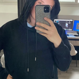 Svart hoodie med dragsko - Skön svart hoodie.