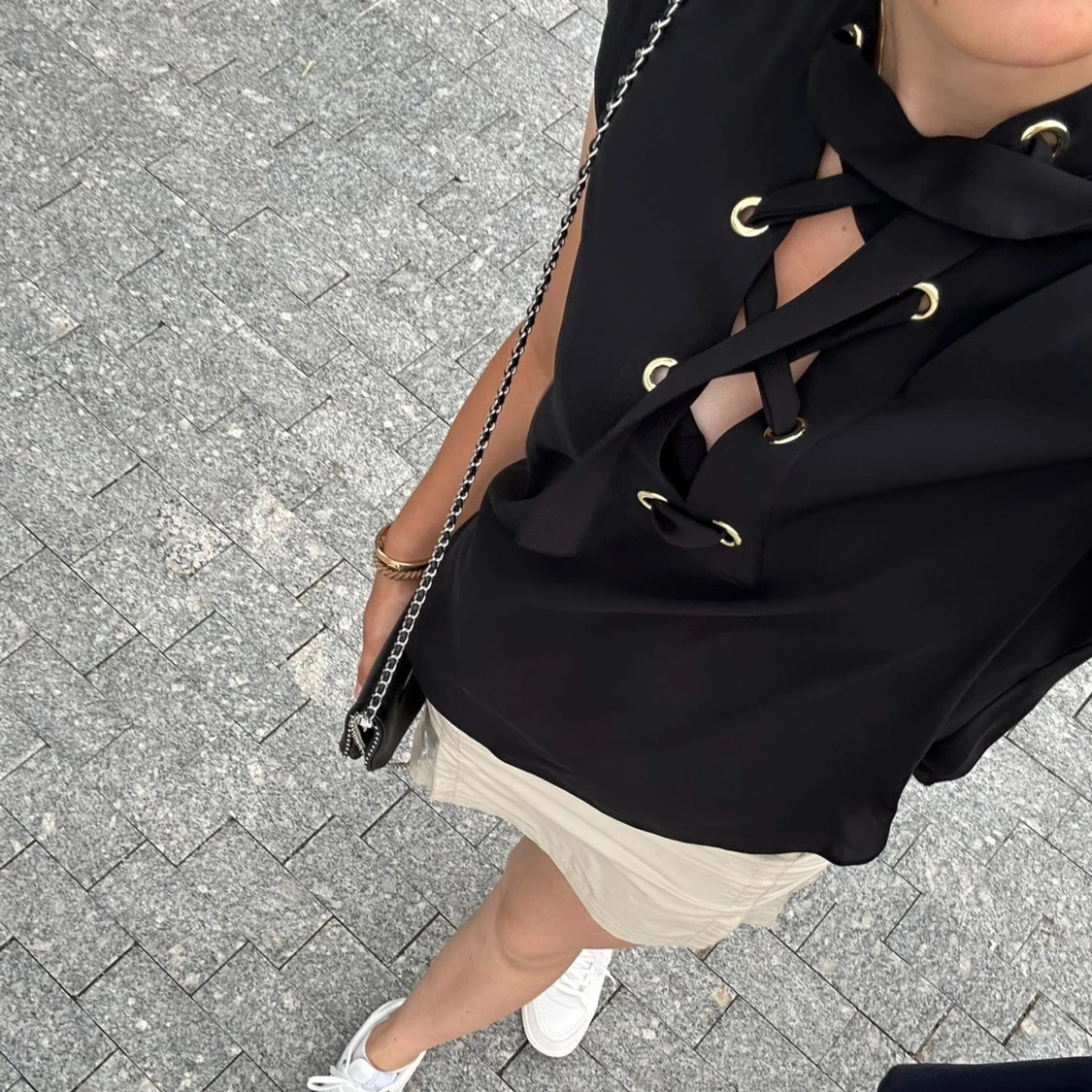 Svart topp med snörning och gulddetaljer