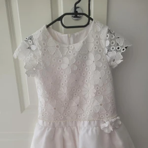Vacker vit barnklänning  - Vit vacker barnklänning för olika fina tillfällen, rätt så fin ser ganska ny ut även fast den burits några gånger i storlek 134/140