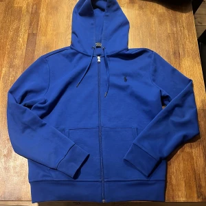 Ralph Lauren Hoodie - Säljer denna stiliga blå Ralph Lauren Hoodien. Endast använd ett fåtal gånger!                   Skick: 9,5/10.                                                        Vid frågor är det bara att skriva😁