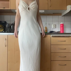 Champagnefärgad långklänning från Adoore - Adoore med v-ringning och smala axelband. Klänningen passar mig eftersom det är storlek 36 och jag har höftmått 98-100 cm