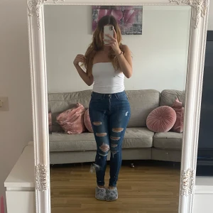  Jeans - Ett par tajta blåa jeans med hål i. Formar kroppen perfekt, stretchigt materiall och högmidjade. Jag kan gå ner i pris vid snabb affär