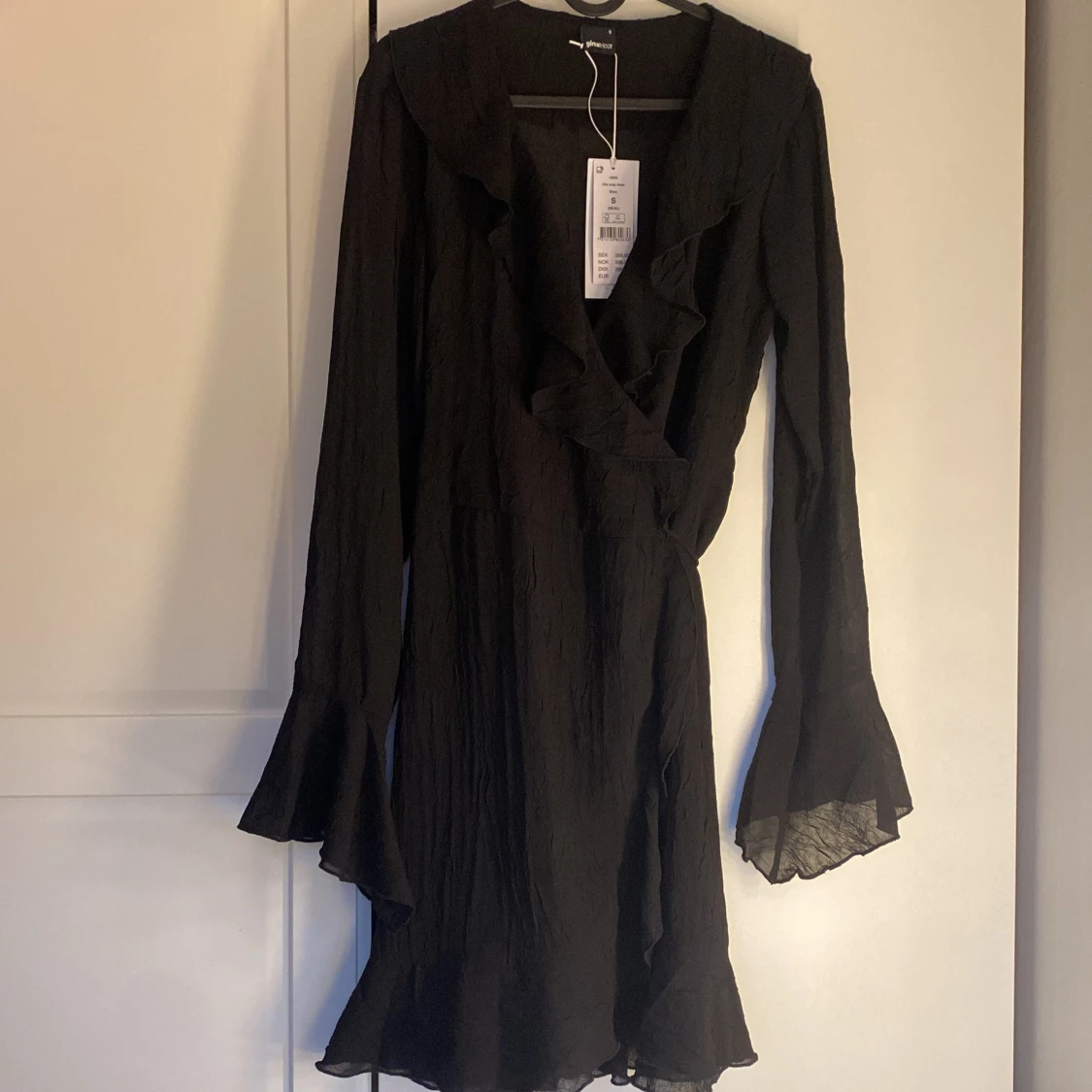 Svart omlottklänning med volang