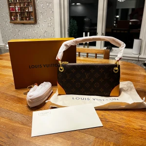 Louis Vuitton Monogram axelväska - Säljer en klassisk axelväska från Louis Vuitton i deras ikoniska monogrammönster. Väskan har guldfärgade metalldetaljer, bruna och beige färginslag samt avtagbar axelrem. Perfekt för dig som vill ha en lyxig accessoar. Hör av dig vid mer frågor och bilder. Aldrig använt då jag köpte för nåt bra tillfälle och la undan den men inget tillfälle för användning har kommit