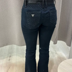 Svarta jeansbyxor med detaljer - Snygga svarta (mörkblåa?) jeansbyxor från Brappers med detaljer på fickorna både fram och bak. Byxorna har bootcut-modell och normal passform. Midjemått: 34 cm Innerbenslängd: 76 cm. Passar mig som är 160 cm, 