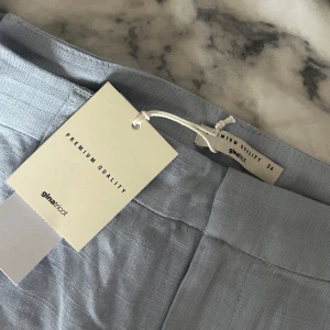 Ljusblå linnebyxor från Gina tricot  - Snygga ljusblå linnebyxor från ginatricot med klassisk passform och 1 diskret fickor bak. Perfekta för en stilren och fräsch look. Byxorna har hällor för bälte och stängs med dragkedja och knapp. Ny pris 500 och prislapp kvar!