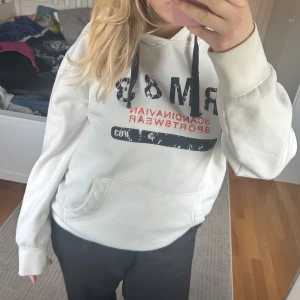 Vit hoodie med tryck  - Vit hoodie med tryck från Race Marine. Köpt second hand men väldigt bra skick. Inte nopprig eller stora fläckar, men ser använd ut. En liten ljusgrå fläck på fickan, skriv om ni vill ha bilder. Tryck gärna på köp direkt 🥰