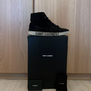 Saint Laurent ”Joe” - Tja! Vill få iväg  mina höga Saint Laurent ”Joe” i strl 42. Väldigt bra skick utöver lite sliten sula och heeldrag plus en liten defekt under sulan som jag kan skicka bild på . Distressingen och texten på sulan är design🤌.