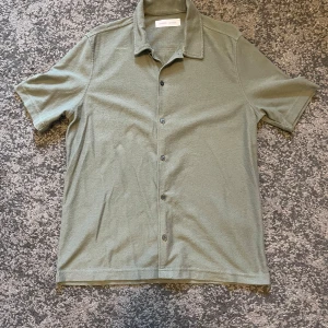 Kortärmad skjorta Samsøe Samsøe - Säljer en kortärmad olivgrön skjorta i storlek S. 54 cm armhåla till armhåla och 73 cm total längd från axel