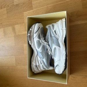 Vita och grå sneakers med meshdetaljer - Säljer ett par chunky vita och grå sneakers med meshpaneler och svarta detaljer. Skorna har snörning och en tjock, mönstrad sula för extra komfort. Perfekta för dig som gillar sportig och trendig stil. Skorna är knappt använda. 