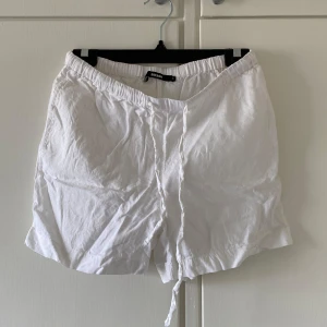 Vita linneshorts från BikBok - Säljer ett par vita shorts från BikBok i luftig linneblandning. De har elastisk midja och snörning framtill för en bekväm passform. Perfekta för varma dagar och enkel att matcha med olika toppar. Helt oanvända💕