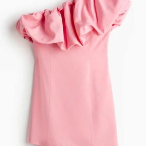 Rosa one shoulder klänning med volang - Säljer denna virala hm klänningen som är en rosa kortklänning med stor volangdetalj över ena axeln! 