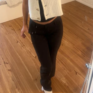 Svarta kostymbyxor med låg midja - Snygga svarta kostymbyxor med låg midja och raka ben. Klassisk design utan synliga detaljer, perfekta för en stilren look. Passar till många olika outfits och är lätta att matcha.