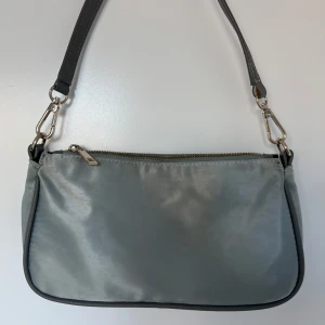 axelväska med dragkedja - grå/blå axelväska med avtagbart axelband och dragkedja upptill. Den är ljusare än vad som syns på bilden. Skriv för fler bilder / mått