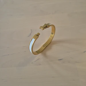 Armband  - Guldigt armband med vita detaljer säljes
