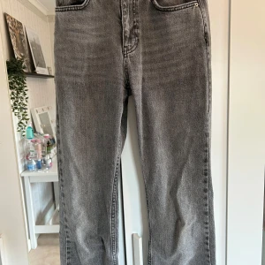 Grå jeans från Gina Tricot - Säljer ett par grå jeans från Gina perfect jeans. Jeansen har raka ben och normal passform, men har klippt upp dem längst ner för längre storlek. Perfekta till vardags och lätta att matcha med olika stilar.