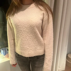 Ljusrosa stickad tröja - Mysig rosa stickad tröja med rund hals. Tröjan har långa ärmar och en rak passform som passar perfekt till jeans eller kjol. Enkel och stilren design som funkar till många tillfällen.