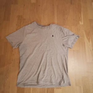 Ljusgrå t-shirt från Polo Ralph Lauren - Säljer en ljusgrå t-shirt från Polo Ralph Lauren med klassisk passform och liten broderad logga på bröstet. T-shirten har rund halsringning och är kortärmad. Perfekt basic-plagg till garderoben.