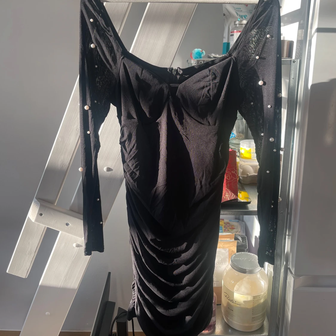 Svart figurnära klänning med pärldetaljer