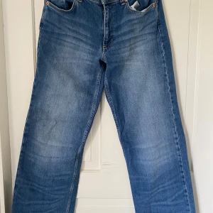 Blå jeansbyxor från Nelly - Säljer ett par klassiska blå jeansbyxor från Nelly med raka ben och normal samt baggy passform. Jenssen är tillverkade i ett robust denimtyg. Perfekta för dig som gillar en tidlös stil. > Jeansen är midrise 💗