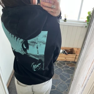 Svart hoodie från h&m - Svart hoodie med ett tryck på ryggen. Säljer då den inte använd länge men den är ganska väl använd men det är inget som syns:)