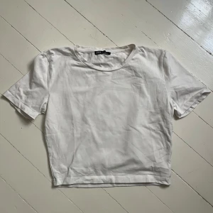 Vit croppad t-shirt från Zara - Säljer en enkel och stilren vit croppad t-shirt från Zara. T-shirten har rund halsringning och korta ärmar, perfekt till sommaren. Passar till det mesta och är lätt att matcha med andra plagg. Skriv för fler bilder💞