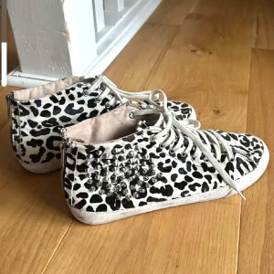 Leopardmönstrade sneakers med nitar - Säljer ett par coola sneakers med  leopardmönster och silverfärgade nitar på sidan. Skorna har snörning och dragkedja där bak för enkel påtagning. 