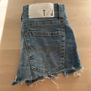 Blå jeansshorts från T/J - Säljer supersnygga lågmidjade shorts från T/J. De har små rivningar på framsidan och är perfekta för sommaren❤️
