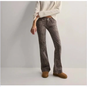Leopardmönstrade bootcut jeans - Snygga bootcut jeans med leopardmönster. Byxorna har normal passform och klassisk femficksdesign med knapp och dragkedja framtill. Perfekta för dig som vill sticka ut med en trendig look.