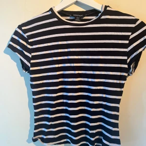 Randig t-shirt från Boohoo - Svart och vit randig t-shirt från Boohoo med  rund hals och korta ärmar. T-shirten har en figursydd passform och är gjord i mjuk bomull. Står att det är strl 40 men jag skulle säga 36 då den krympt. Frakt tillkommer