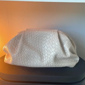 Beige clutch  - Öppen i diskussion om pris.  Säljer en beige clutch med croco-mönstrad yta i syntetmaterial. Väskan är mjuk och rymlig. Har en stilren, modern look. Perfekt att bära under armen för en trendig vibe.