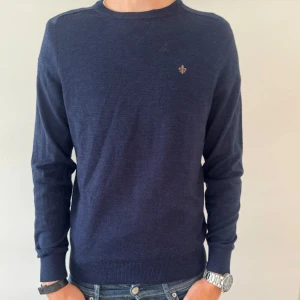 MORRIS MERINOULL TRÖJA - Snygg marinblå tröja från Morris i mjuk merinoull. Klassisk rund halsringning och diskret logga broderad på bröstet. Perfekt passform. Enkel att matcha till jeans eller chinos. Som ny.