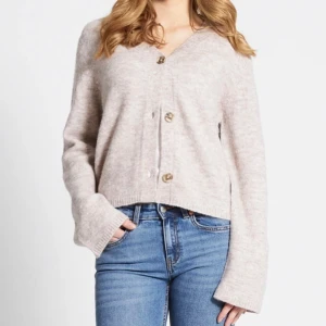 Beige stickad kofta med knappar  - Mysig beige kofta från 157 med v-ringning och stora knappar framtill. Koftan är stickad och har långa ärmar med lite loose fit. 