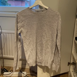 Ljusgrå tröja från Bläck - En stilren ljusgrå tröja från Bläck i storlek S. Tröjan har rund halsringning, långa ärmar och är tillverkad i mjuk bomull. Perfekt för lager-på-lager och enkel att matcha med jeans eller chinos.