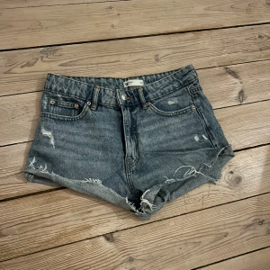 Blå jeansshorts från g perfect jeans - Snygga blå jeansshorts med hög midja från g perfect jeans. De har slitna detaljer, råa kanter och klassisk femficksdesign. Perfekta för en chill sommarlook med lite edge. Passar dig som gillar en avslappnad och trendig stil. Måste tyvärr sälja dom på grund av att dom är för små. Hör gärna av dig om du är intresserad!🥰