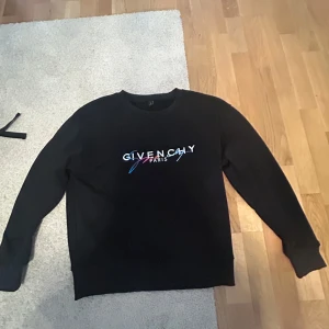 Svart Givenchy sweatshirt - Svart sweatshirt från Givenchy med färgglad logotyp på bröstet. Tröjan har rund halsringning och långa ärmar. Perfekt för dig som gillar stilrena plagg med en exklusiv touch.