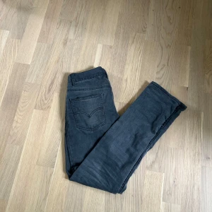 Levi's 512 Slim Taper svarta jeans - Snygga svarta Levi's 512 Slim Taper jeans med klassisk femficksdesign och smal passform som smalnar av vid ankeln. Jeansen har en mörk tvätt och är tillverkade i mjukt denimtyg med stretch för extra komfort. Perfekta för en clean och stilren look.