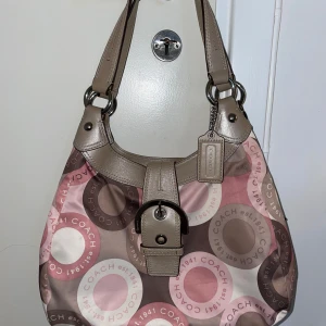Vintage coach väska - Har inget bevis på att den är äkta, då jag inte är säker heller. Men efter att ha undersökt den och jämfört med bilder så verkar den legit. De säljs för över 1600kr. Det finns ett par fläckar under väskan som visas på en av bilderna