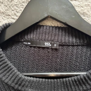 Svart stickad tröja från 157 - En svart, grovstickad tröja från 157 med rund halsringning och långa ärmar. Enkel och stilren design som passar perfekt till jeans eller kjol. Säljer pågrund av att den inte kommer till någon användning längre🙂